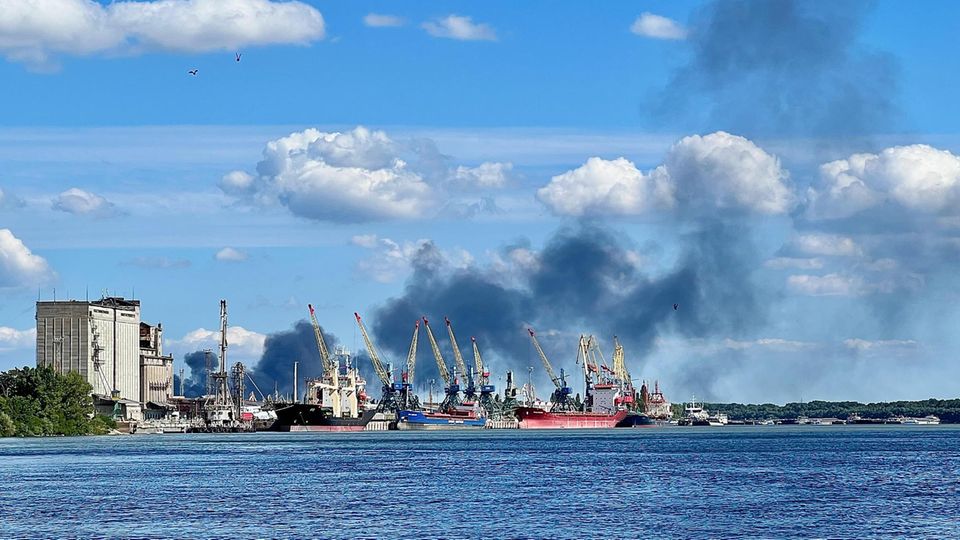 A harbor with ships and clouds of black smoke
