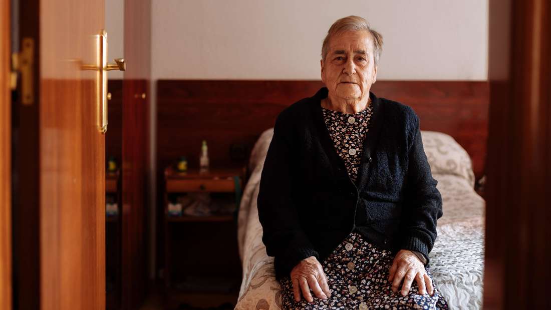 Elderly sits on bed