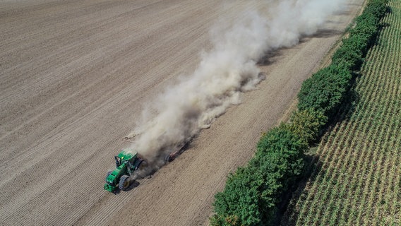 Aerial view of a tractor on a field raising dust.  © picture alliance Photo: Patrick Pleul