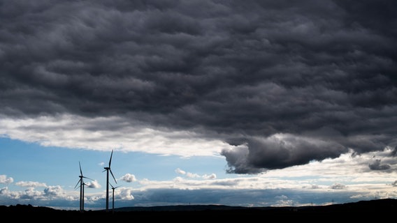 Dark storm clouds pass over wind turbines.  © picture alliance/dpa Photo: Julian Stratenschulte