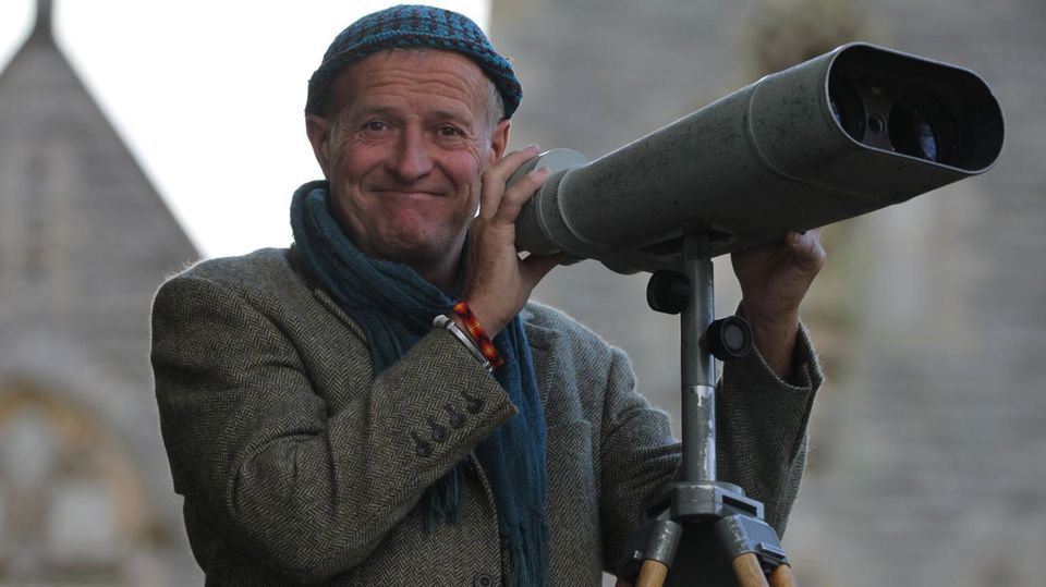 Steve Feltham stands in front of giant binoculars