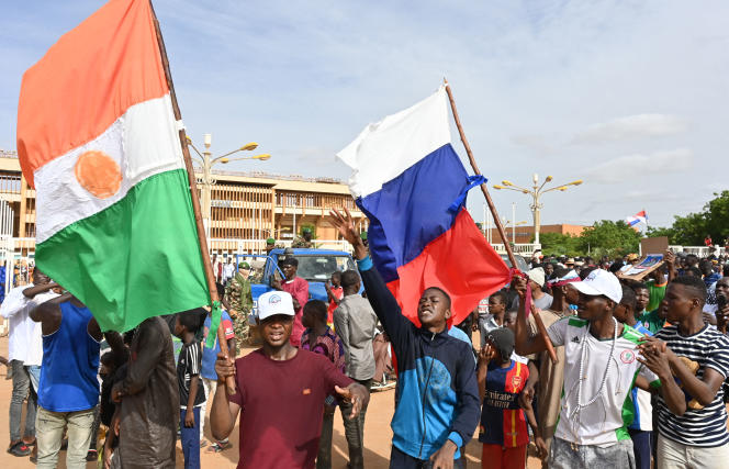 Supporters of the putschists in Niger wave Russian and Nigerien flags during a demonstration in Niamey on August 6, 2023.
