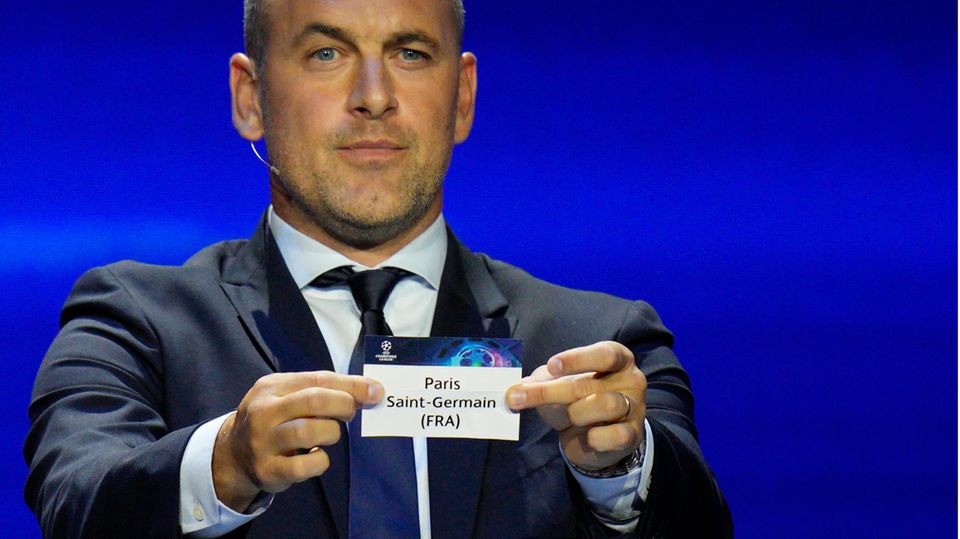 Former soccer player Joe Cole shows off a ticket from Paris Saint-Germain