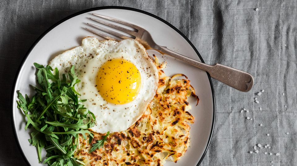 Fried egg, potatoes and salad are on a plate