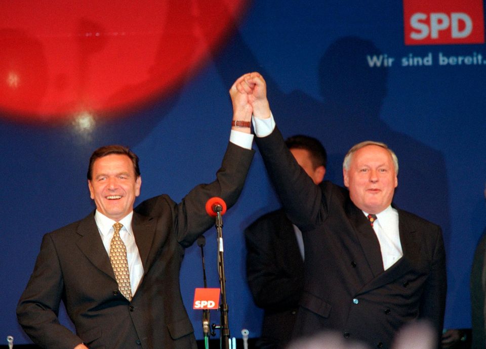 Gerhard Schröder und der SPD-Vorsitzende Oskar Lafontaine (r) halten sich jubelnd an den erhobenen Händen, als sie mit ihren Anhängern am 27.9.1998 vor der Bonner Parteizentrale den Sieg Gerhard Schröders als Kanzler feiern