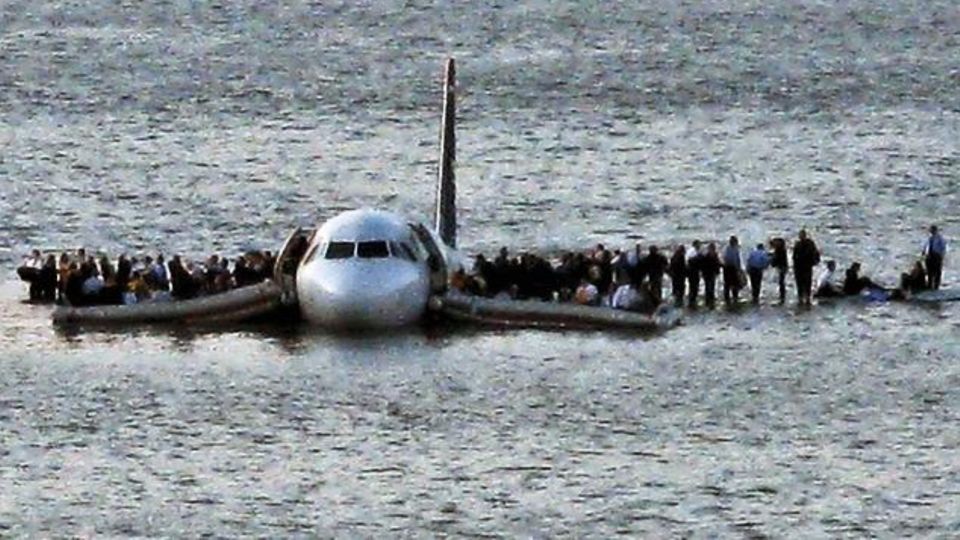 Airline passengers wait to board a ferry to be rescued on the wings of a US Airways Airbus 320 jetliner that safely ditched in the frigid waters of the Hudson River in New York, Thursday Jan. 15, 2009 after a flock of knocked birds out both its engines....
