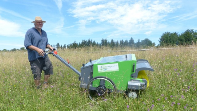 Nature in Bavaria: Farmer Konrad Schinkinger with his harvesting machine for meadow flower seeds.