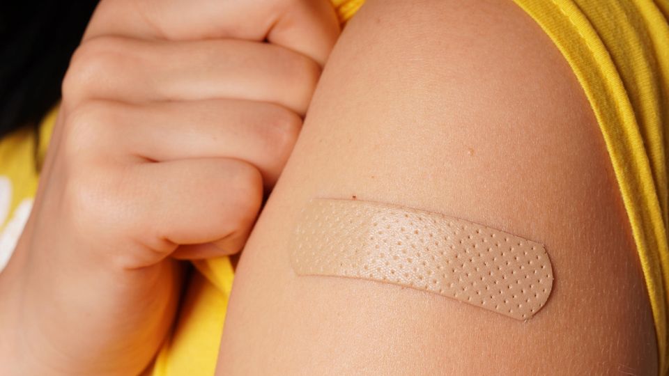 An adhesive plaster sticks to the upper arm after vaccination