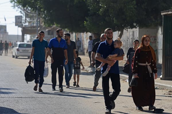 Des habitants de la bande de Gaza fuient leur maison, après des frappes venues d'Israël, le 7 octobre 2023