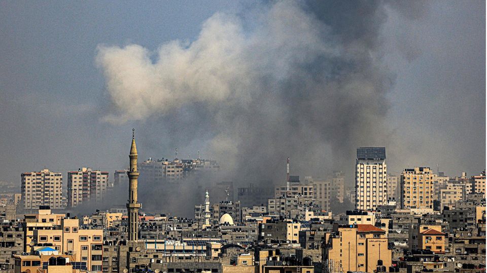 A cloud of smoke rises over buildings in the Gaza Strip after an Israeli airstrike