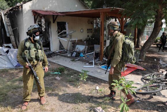 Israeli soldiers inspect the damage caused by rocket fire from the Gaza Strip in the Kibbutz of Kfar Aza, on the border with the Palestinian territory, October 10, 2023.