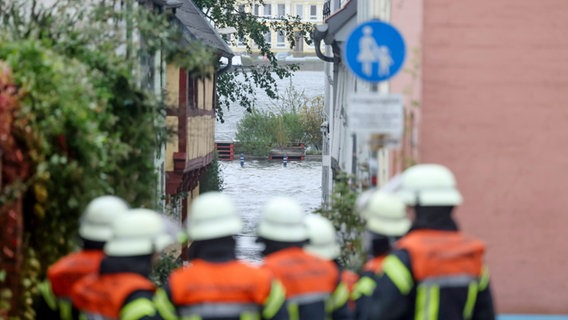 Einsatzkräfte der Feuerwehr in Flensburg besprechen sich. Ein mächtiger Sturm hat das Ostseewasser ans Land gedrückt und für Überschwemmungen in Schleswig-Holstein gesorgt. © Frank Molter/dpa 