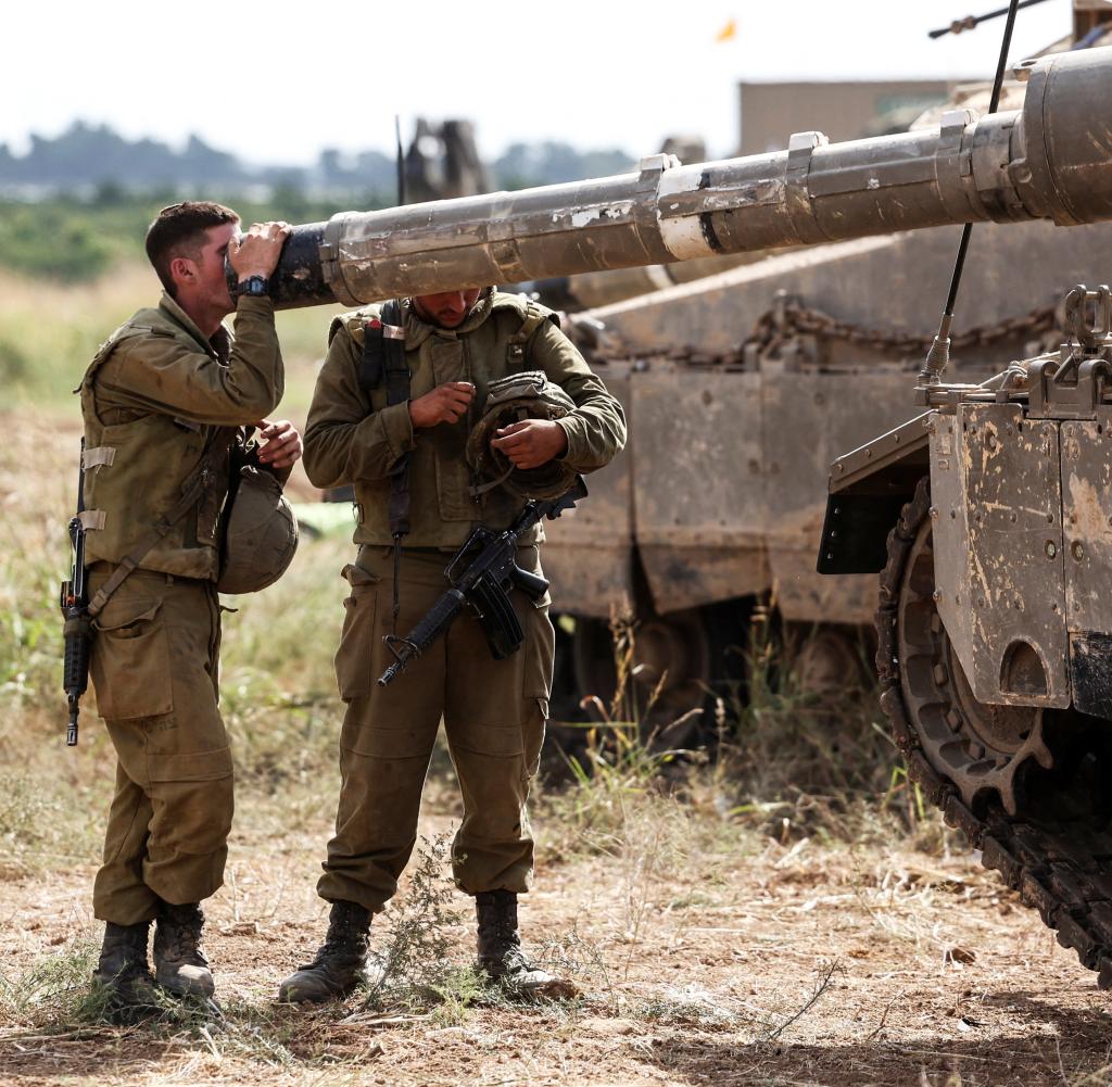 Israeli soldiers check a tank near the Gaza border