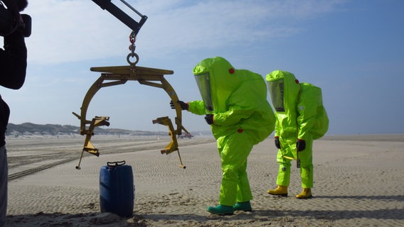 Two people in light green protective suits during an emergency commando exercise on the beach in Wangerooge © NDR Photo: Matthias Schuch