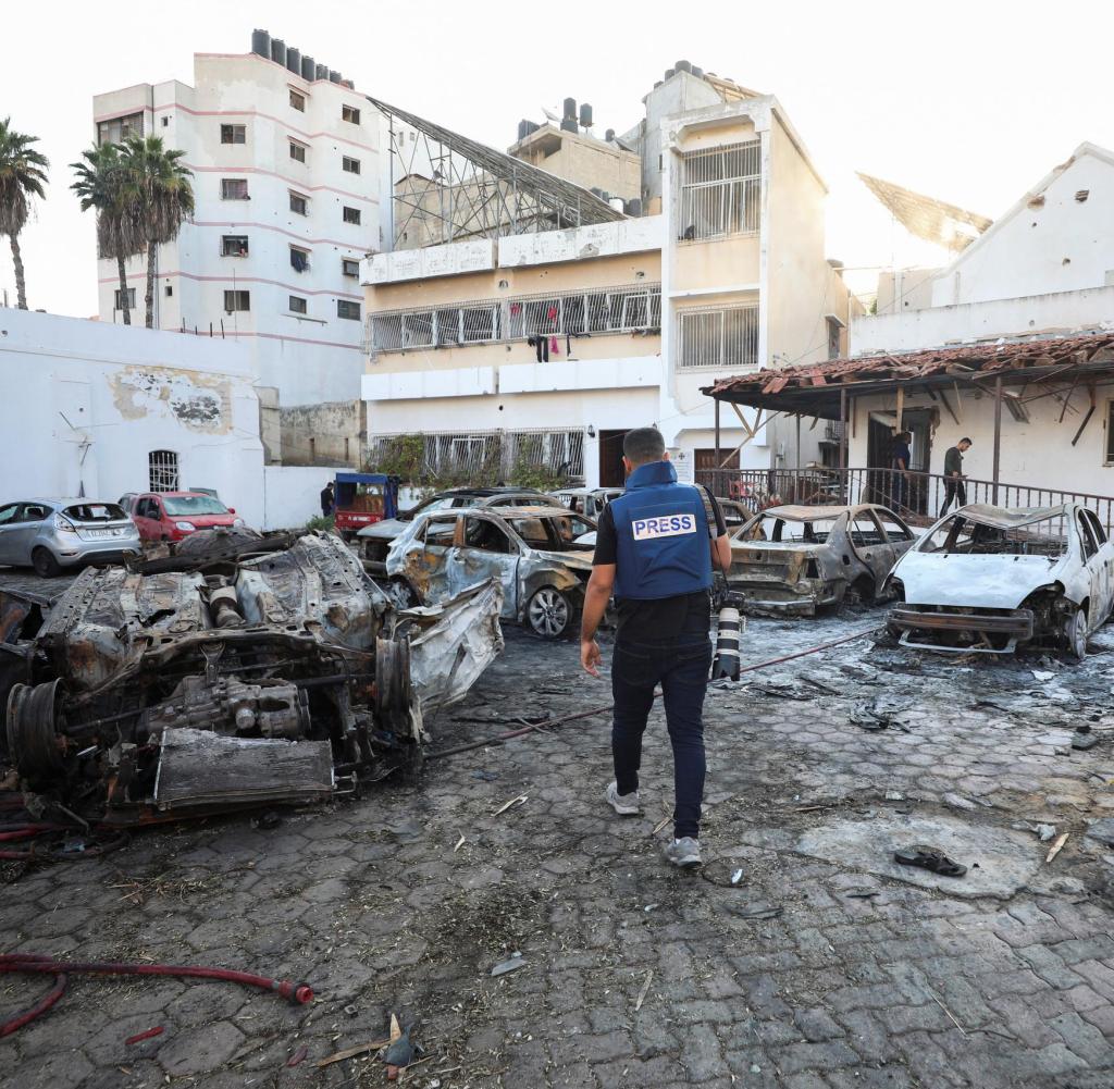 A member of the media walks at the area of Al-Ahli hospital where hundreds of Palestinians were killed in a blast that Israeli and Palestinian officials blamed on each other, and where Palestinians who fled their homes were sheltering amid the ongoing conflict with Israel, in Gaza City, October 18, 2023. REUTERS/Mohammed Al-Masri