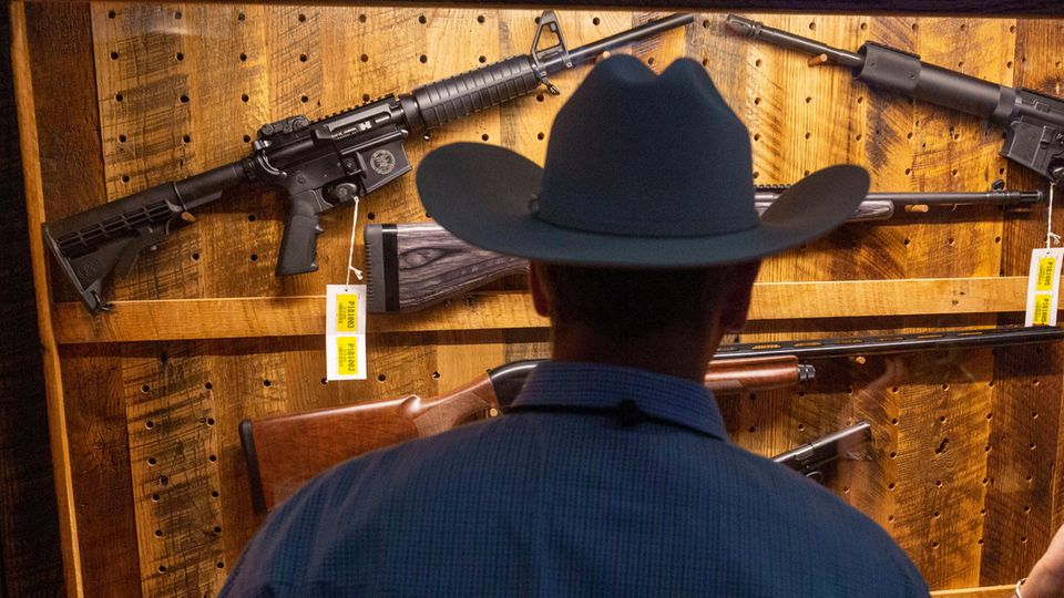 A man inspects weapons at a show organized by the NRA gun lobby.  For many Americans, guns are part of their culture