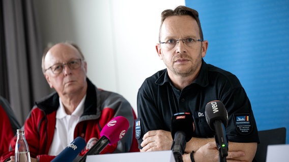 Michael Ippich (l) from the German Society for the Rescue of Shipwrecked Persons, Robby Renner (r), head of the accident command, at a press conference © dpa-Bildfunk Photo: Sina Schuldt