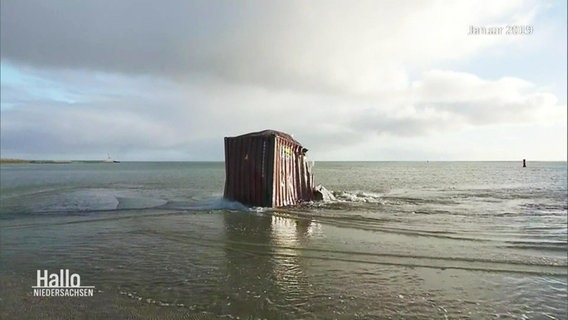 A damaged container is pulled ashore.  © Screenshot 