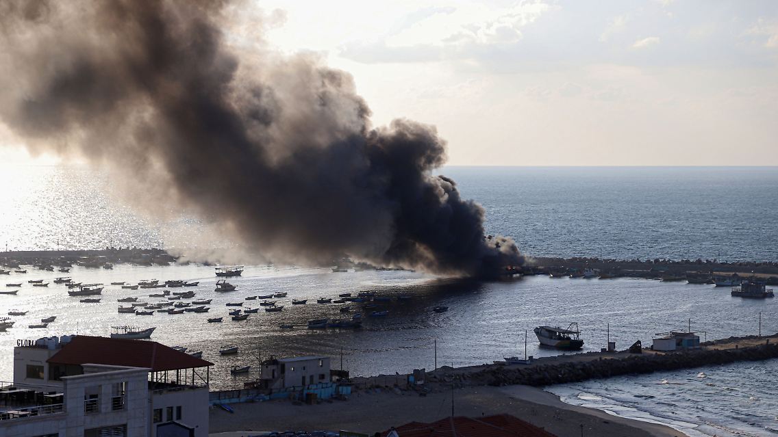 Rauch steigt von brennenden Fischerbooten auf, die durch einen israelischen Luftangriff im Hafen von Gaza-Stadt verursacht wurden.
