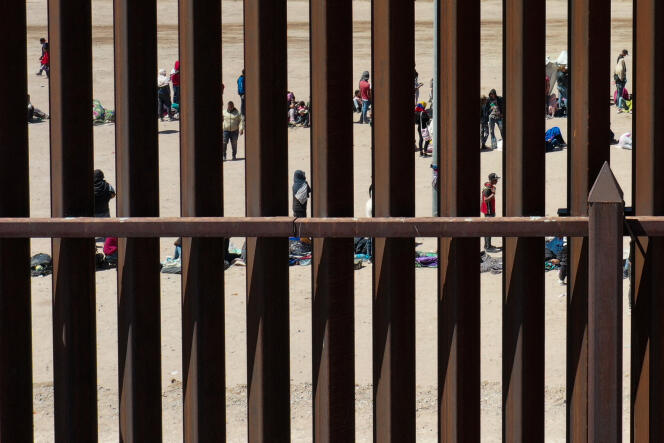 Migrants wait behind a wall on the border between the United States and Mexico, after crossing the Rio Grande, May 11, 2023. 