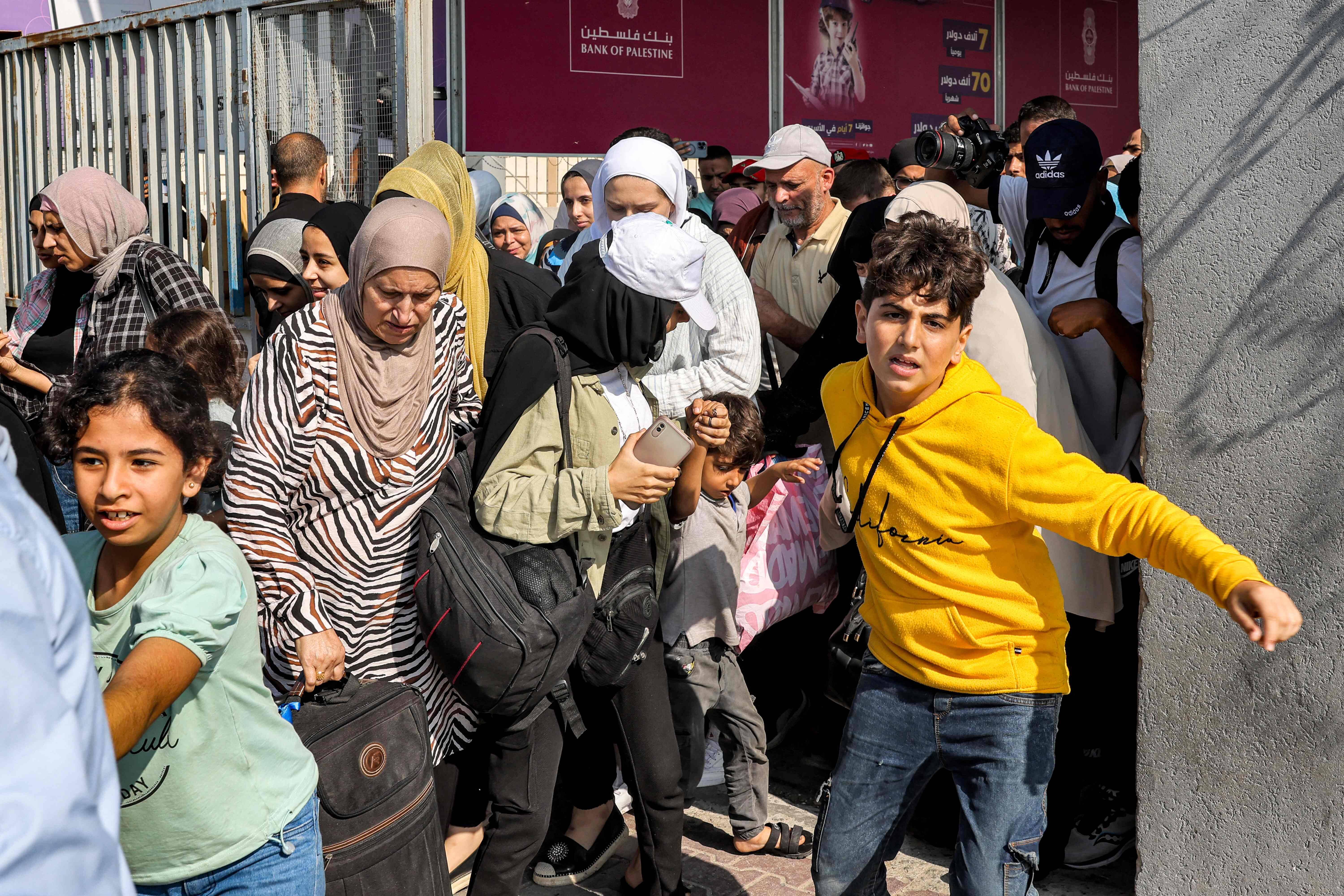 Des Palestiniens se précipitent pour passer le poste frontière de Rafah vers l'Egypte. — © MOHAMMED ABED / AFP