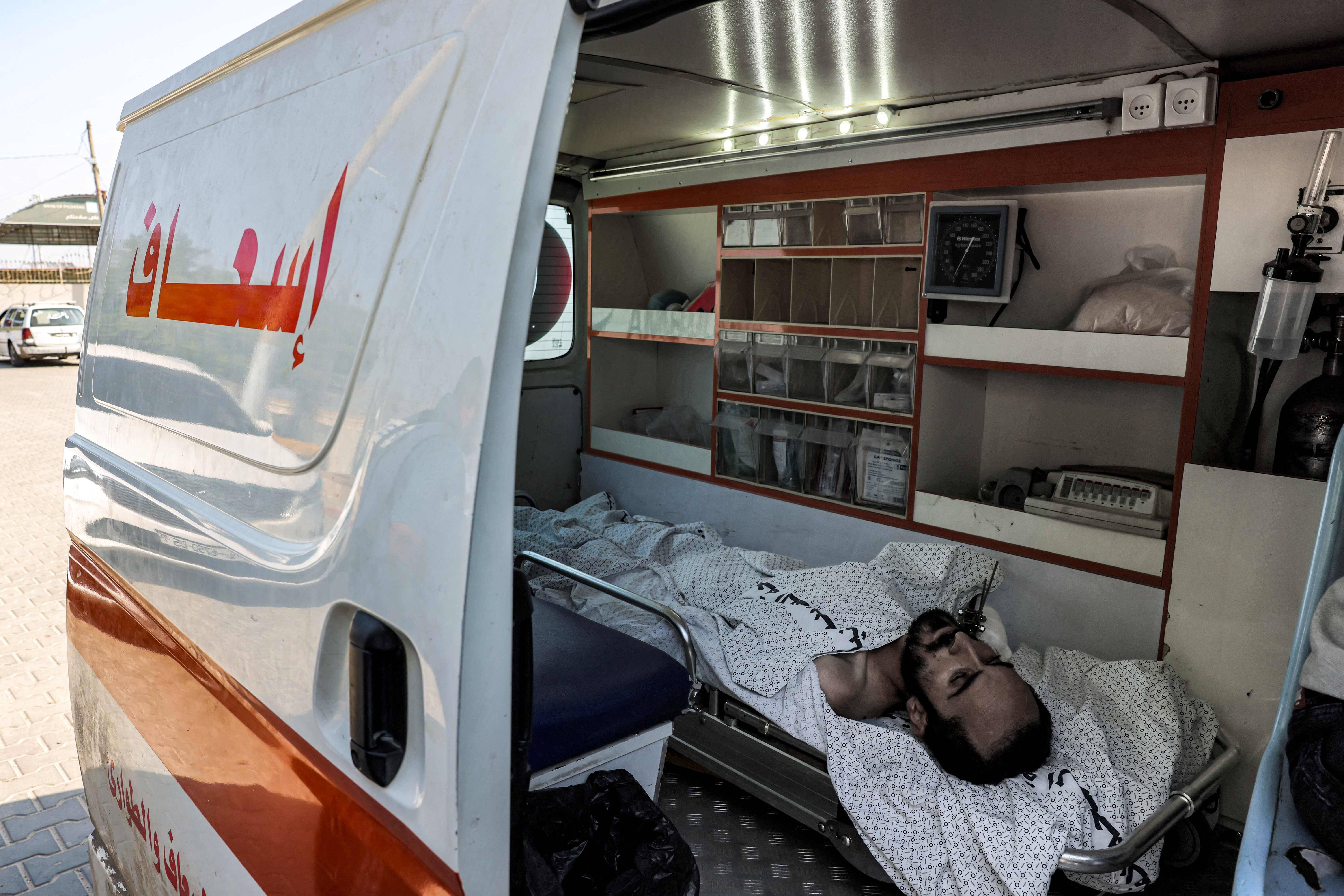Un homme blessé dans une ambulance, qui attend de pouvoir traverser la frontière entre la bande de Gaza et l'Egypte. — © MOHAMMED ABED / AFP