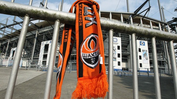 A Shakhtar Donetsk scarf hangs on the fence of the Volksparkstadion, the HSV arena, in Hamburg.  © Imago Images Photo: Hanno Bode