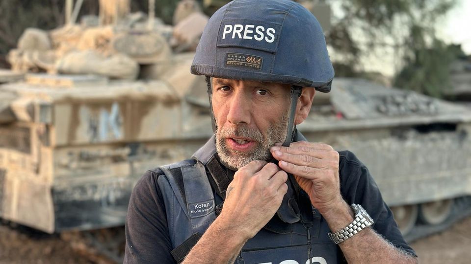 War photographer Ziv Koren closes his protective helmet, portrait on a mission