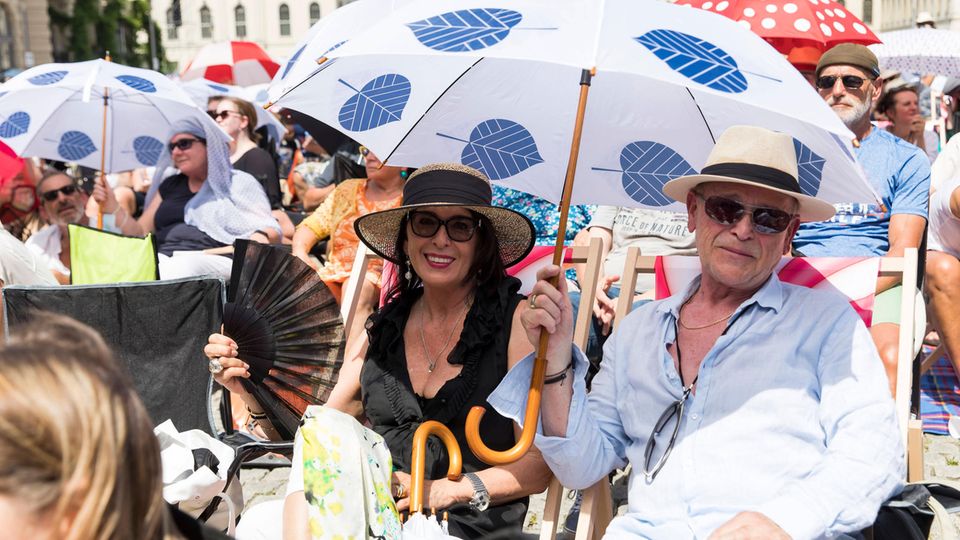 People with sun hats and umbrellas in place