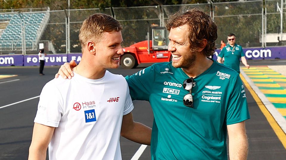 Mick Schumacher and Sebastian Vettel on the side of a race track