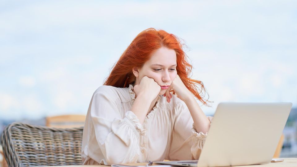 Woman sits frustrated in front of her laptop