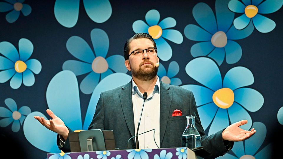 Party leader Jimmie Åkesson of the Sweden Democrats in front of blue and yellow flower logos