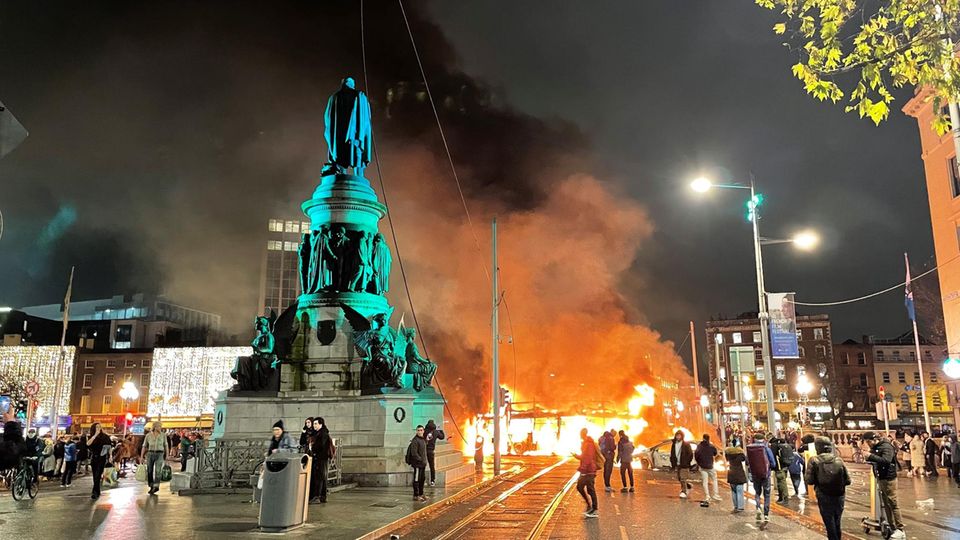 Riots break out in Dublin after a knife attack.  A bus is on fire.