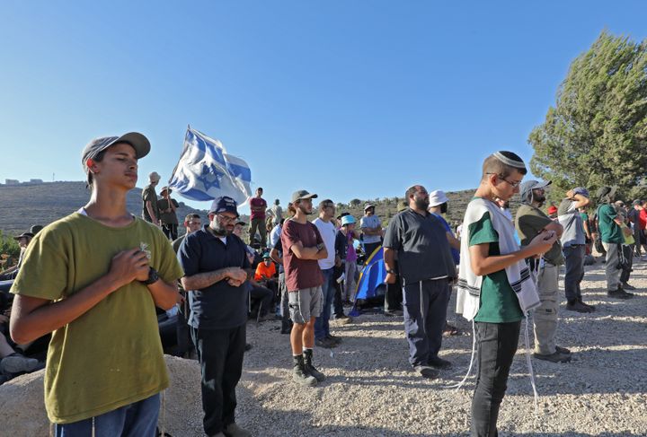 Des colons israéliens durant une prière, pendant une tentative d'établir un avant-poste près de la colonie de Talmon, le 20 juillet 2022 en Cisjordanie occupée. (GIL COHEN-MAGEN / AFP)