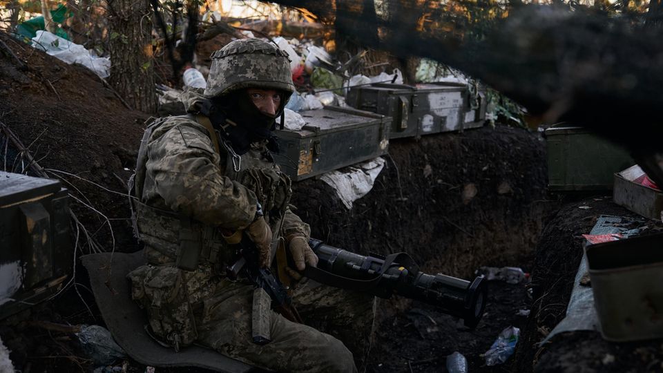 A Ukrainian soldier in an improvised trench.