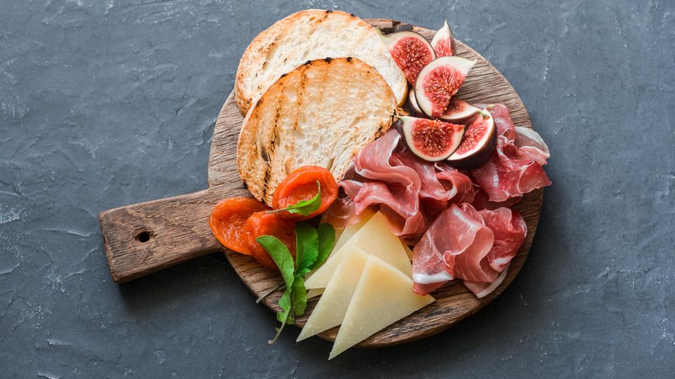 Tiktok: Girl Dinner – A wooden plate with.  Bread, ham and cheese