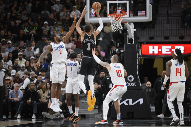 Victor Wembanyama, dressed in the black San Antonio Spurs jersey, in the middle of the Los Angeles Clippers defense.  November 22, 2023, in Texas. 