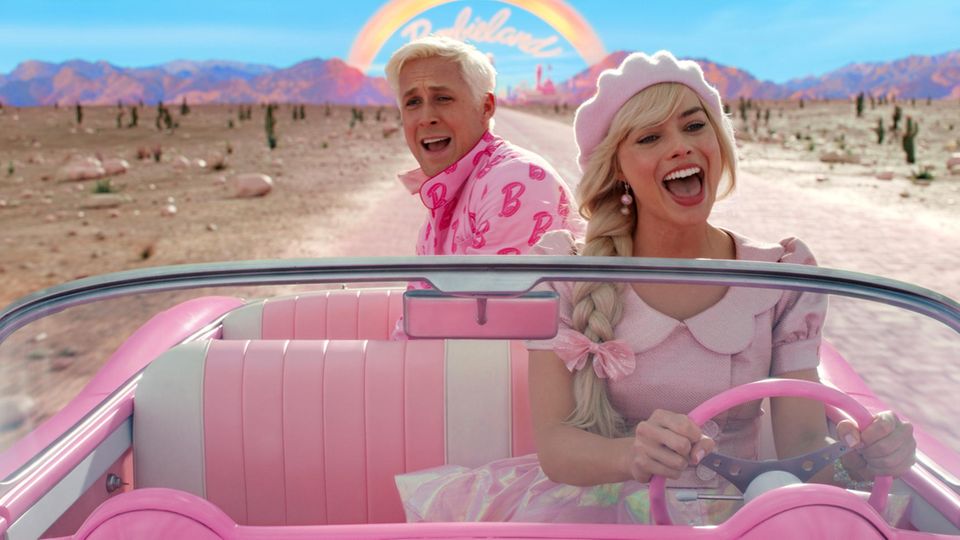 Ryan Gosling as Ken and Margot Robbie as Barbie sit in a convertible in the film "Barbie."