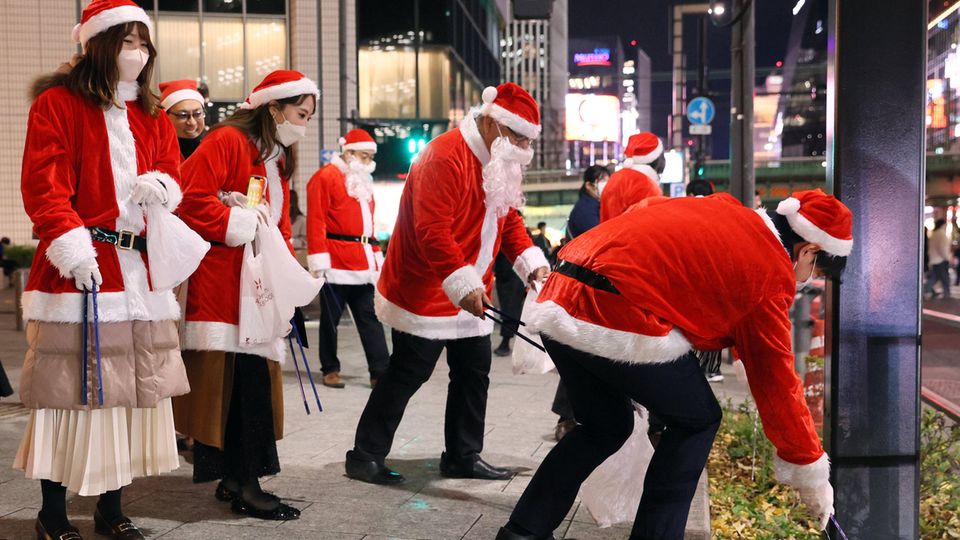 People in Christmas costumes collect garbage