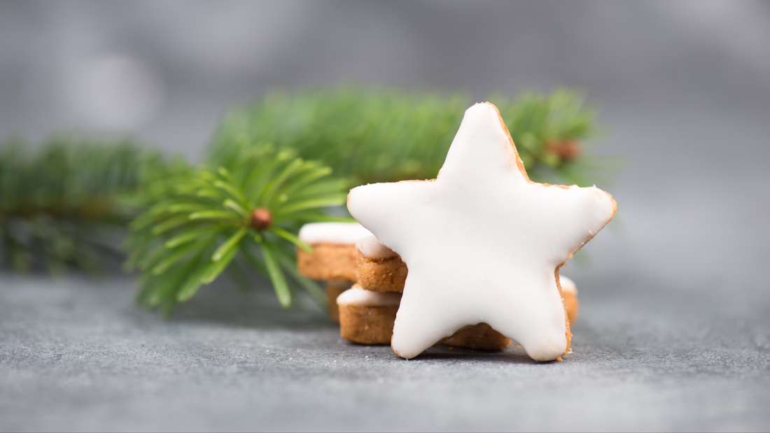 Cinnamon stars with icing in front of a pine branch