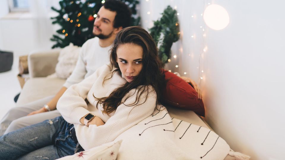 Argument at Christmas: A couple sits on a couch