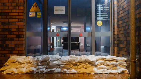 Sandsäcke liegen vor dem Eingang der Sparkasse Rodenberg. © dpa Foto: Ole Spata