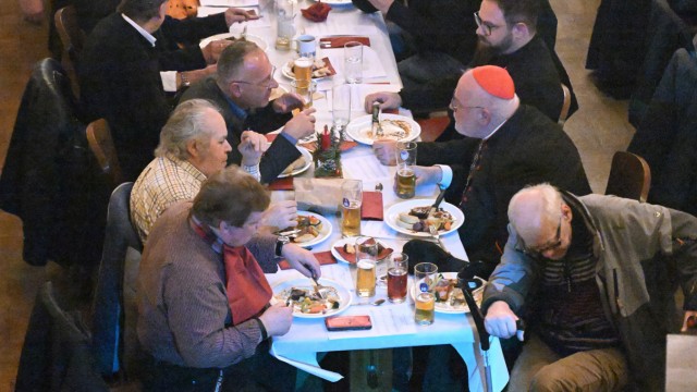 Christmas dinner for the needy: The Archbishop of Munich and Freising enjoys the menu together with the needy.