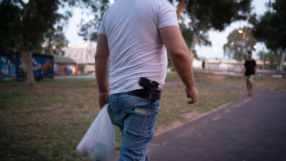 A man carries a gun in his belt