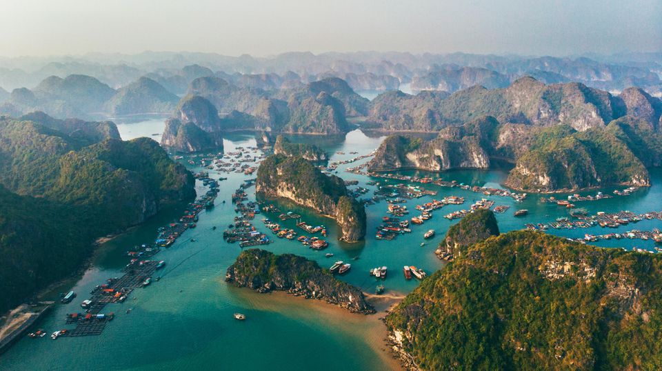 View from above: Halong Bay in Vietnam - Many rock formations rise out of the blue, clear water.