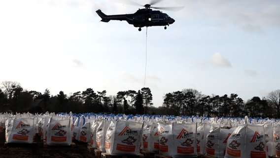 Ein Bundespolizei-Hubschrauber transportiert Sandsäcke. © NonstopNews 