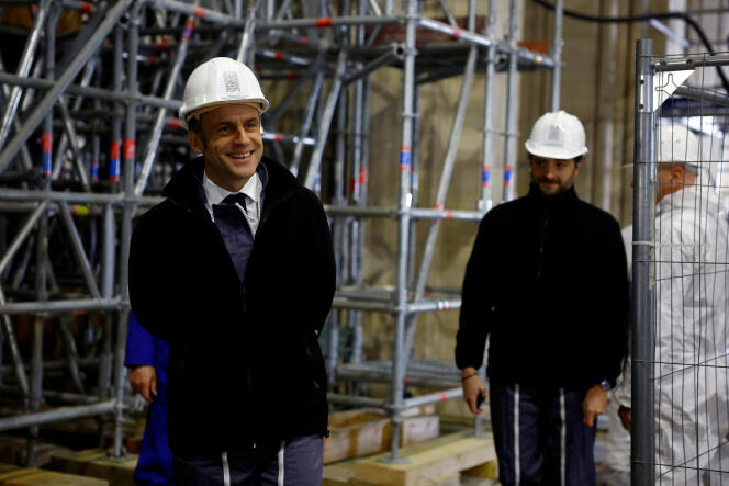 Emmanuel Macron arrives in the nave of Notre-Dame de Paris Cathedral, to visit the construction site of the building one year before its reopening to the public, on December 8, 2023. 