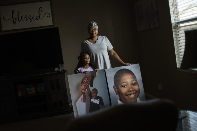 Teresita Horne, accompanied by her daughter, Lucy, shows photos of her son, Donovan James Jones, at their home in Buckeye, Arizona, March 19, 2022. Jones was born with sickle cell anemia and died at age 13 from complications of Covid-19, November 12, 2021.