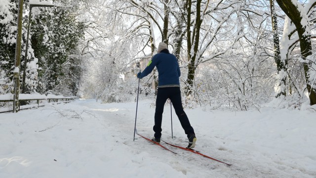 Munich snow moments: Trees and bushes covered in ice: cross-country skiers on the Isar.