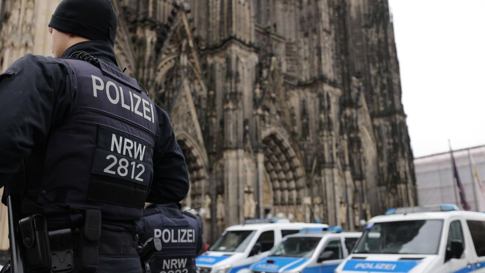 Police officers patrol in front of Cologne Cathedral.